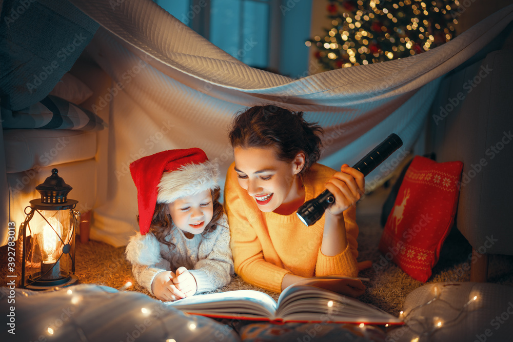 母亲在圣诞树旁给女儿读书