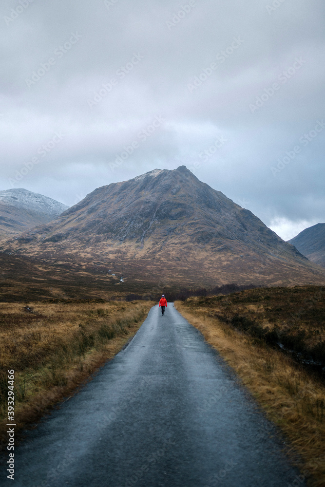 苏格兰Glen Etive的一名妇女走在路上