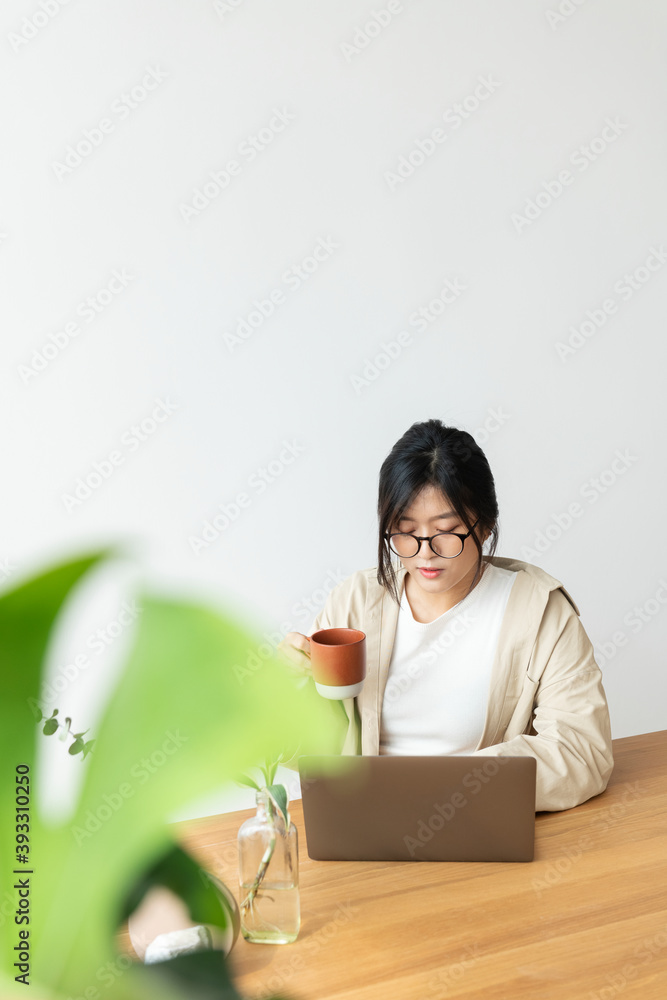 亚洲女性在家工作时喝咖啡