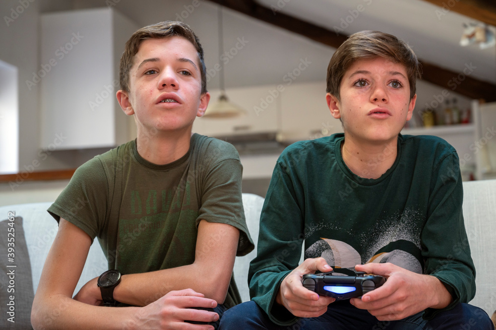 Adolescents jouant à la console de jeux à la maison