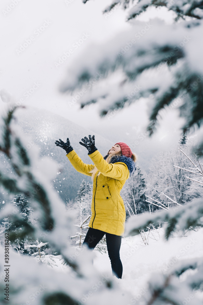 穿着黄色夹克的快乐女孩在山上撒雪，很快乐。冒险和旅行conc