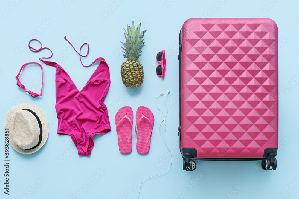 海滩配饰套装，带行李箱和彩色背景女性泳衣