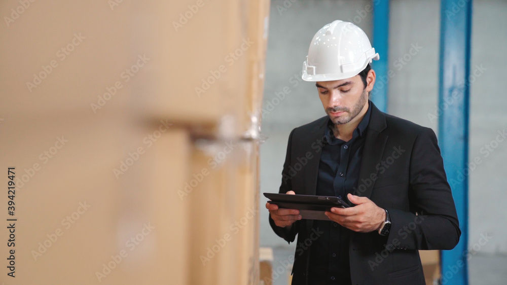 Factory manager using tablet computer in warehouse or factory . Industry and supply chain management
