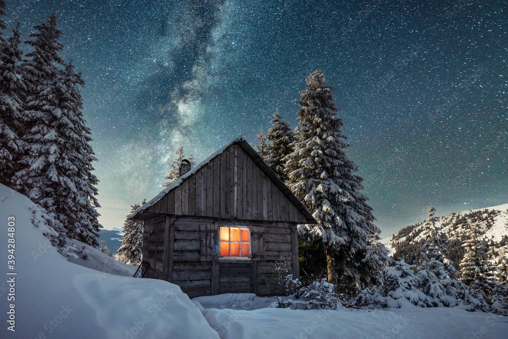 雪山木屋的奇妙冬季景观。银河和雪的星空
