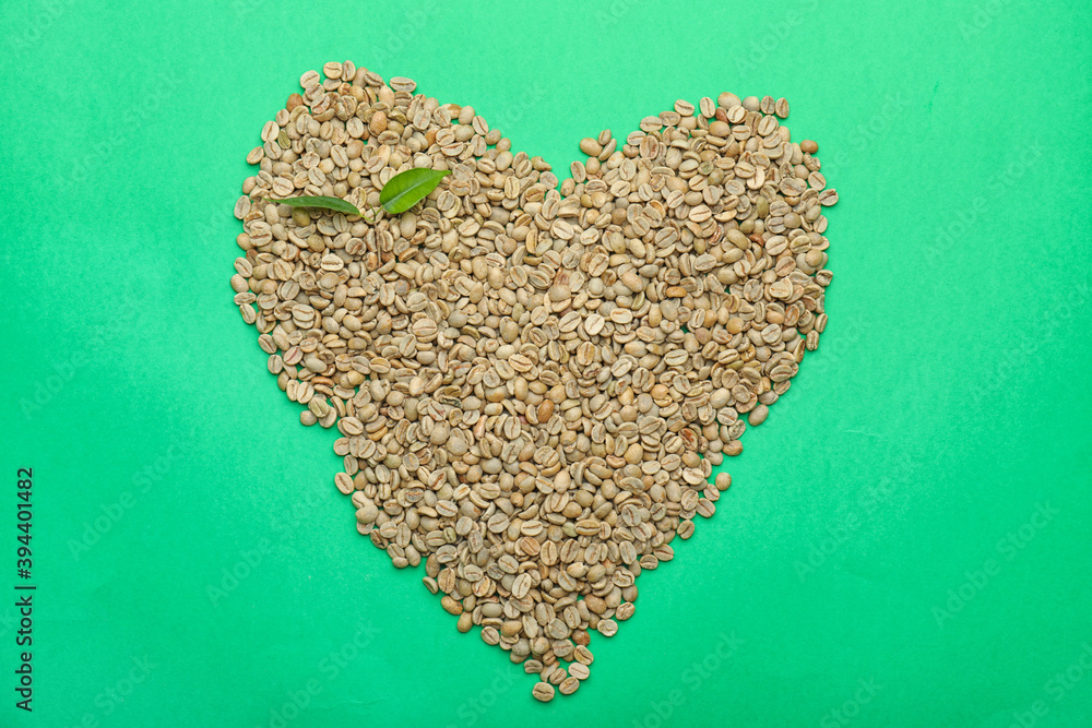 彩色背景上的绿色咖啡豆做成的心形