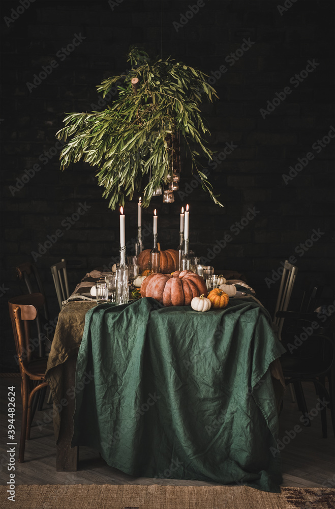 时尚质朴的感恩节派对餐桌。绿色亚麻桌布的实心餐桌，晚餐