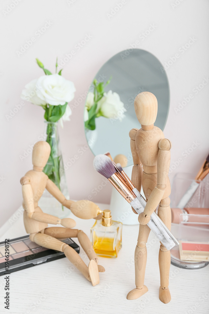 房间桌子上有化妆化妆品和配件的木制人体模型