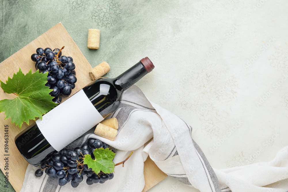 一瓶以新鲜葡萄为背景的红酒