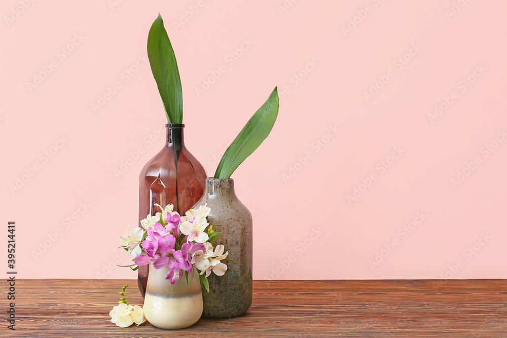彩色背景下木桌上摆放的花瓶，花瓶上有一束鲜花