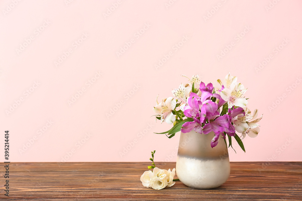 漂亮的花瓶，彩色背景的木桌上有花束