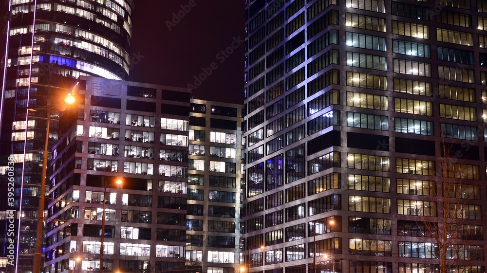 夜间照明的办公楼窗户图案。玻璃建筑立面照明