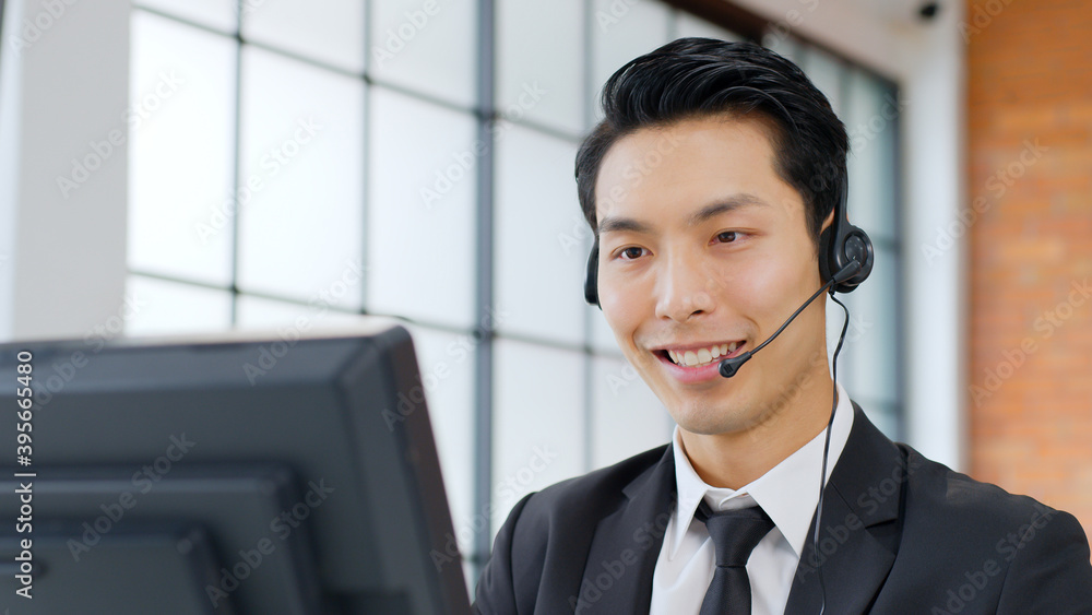 近距离亚洲男子呼叫中心、客户服务、穿着正装戴耳机或头戴式耳机的电话销售