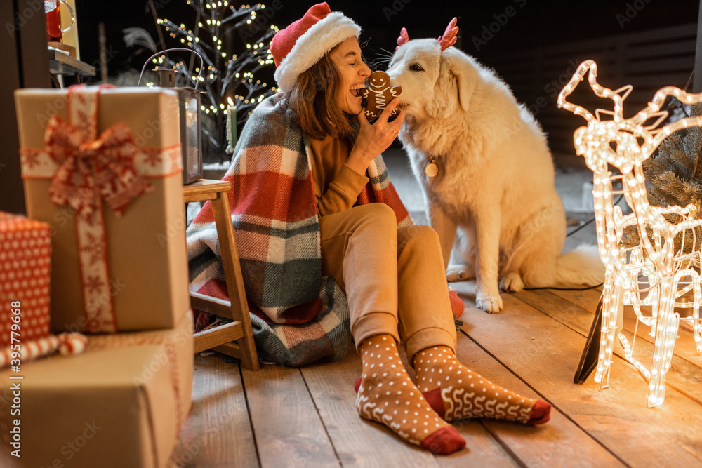 一位戴着圣诞帽、梳着辫子的女士和她的可爱小狗在庆祝新年假期的肖像