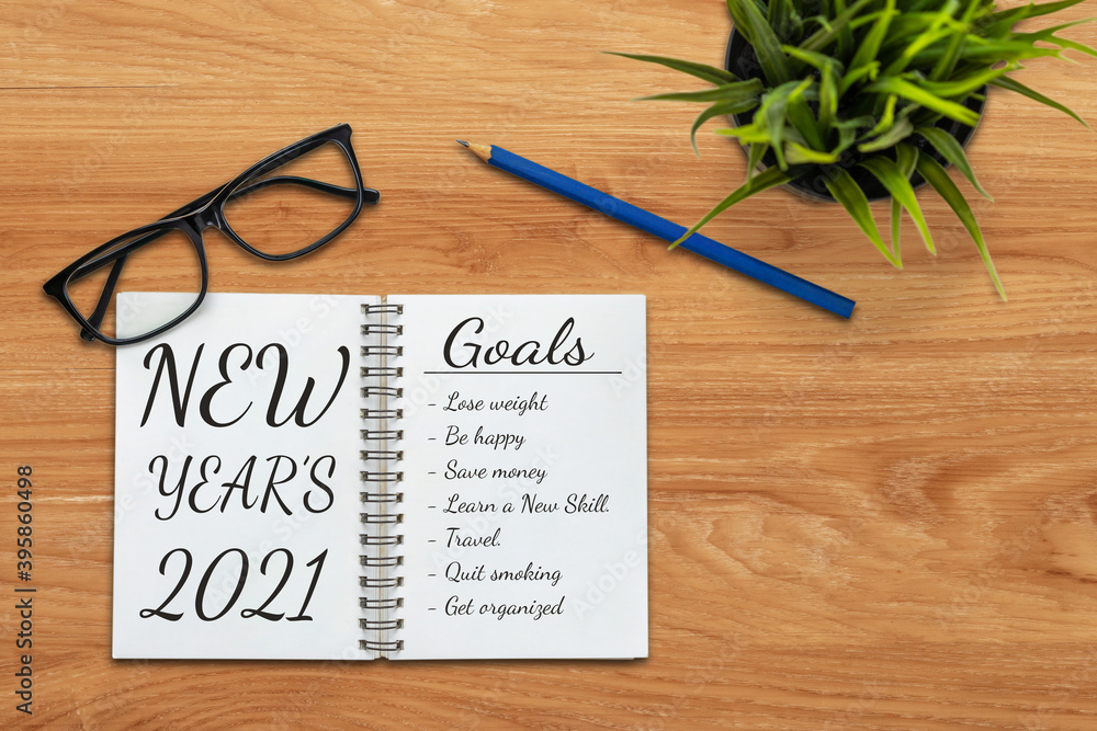 2021 Happy New Year Resolution Goal List - Business office desk with notebook written in handwriting