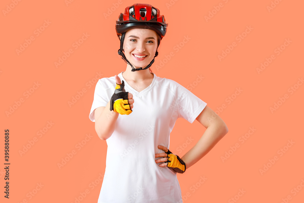 女自行车手在彩色背景上竖起大拇指