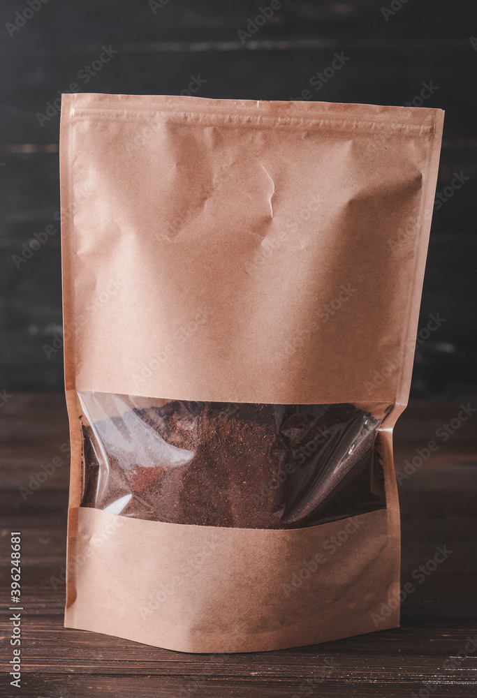 Pack with coffee powder on wooden background