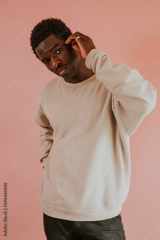 非裔美国人穿着粉色背景的白色毛衣模型