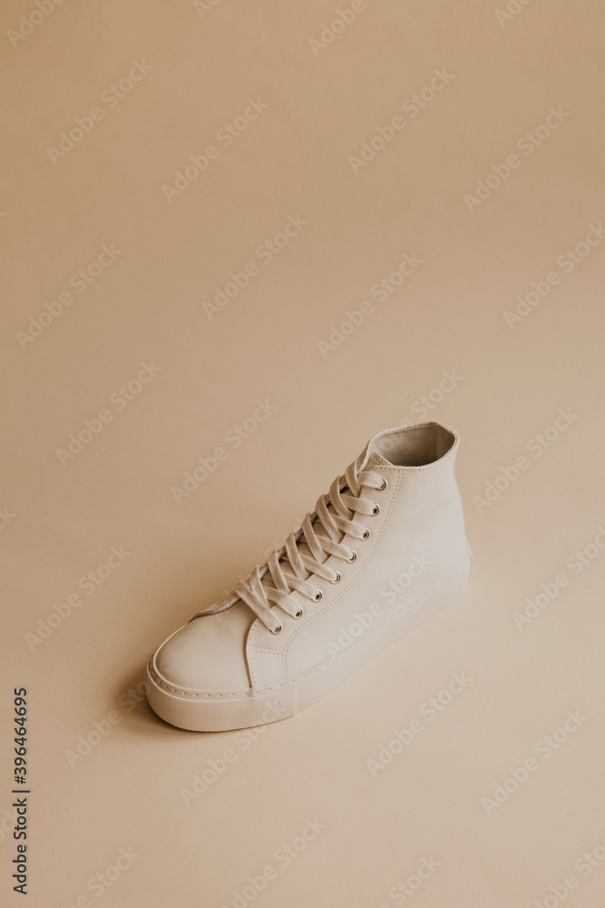 White high top sneakers on beige