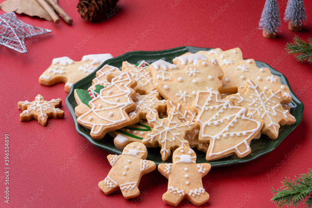Close up of Christmas sugar cooikes in a plate on red table background.