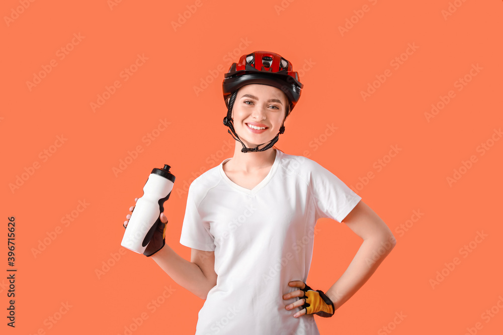 女自行车手饮用彩色背景水