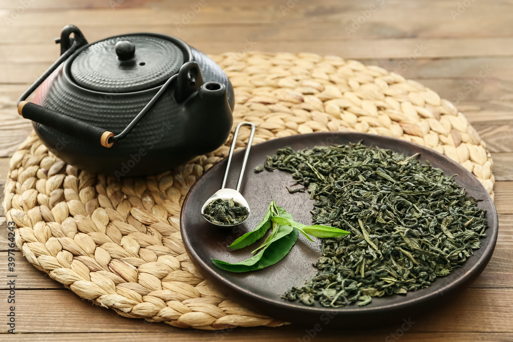 木桌上的茶壶和干绿茶