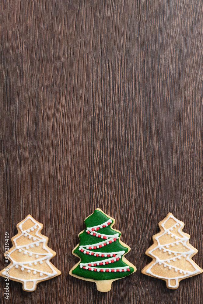 Close up of drawing Christmas tree sugar cookie on wooden table background with icing.
