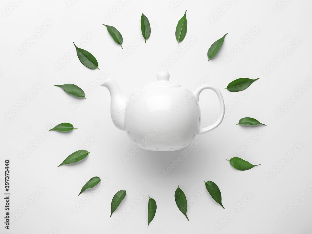 白底茶壶和绿茶叶