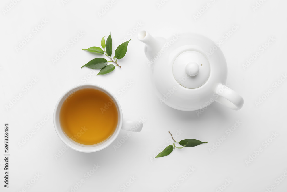 茶壶、一杯茶和白底绿叶