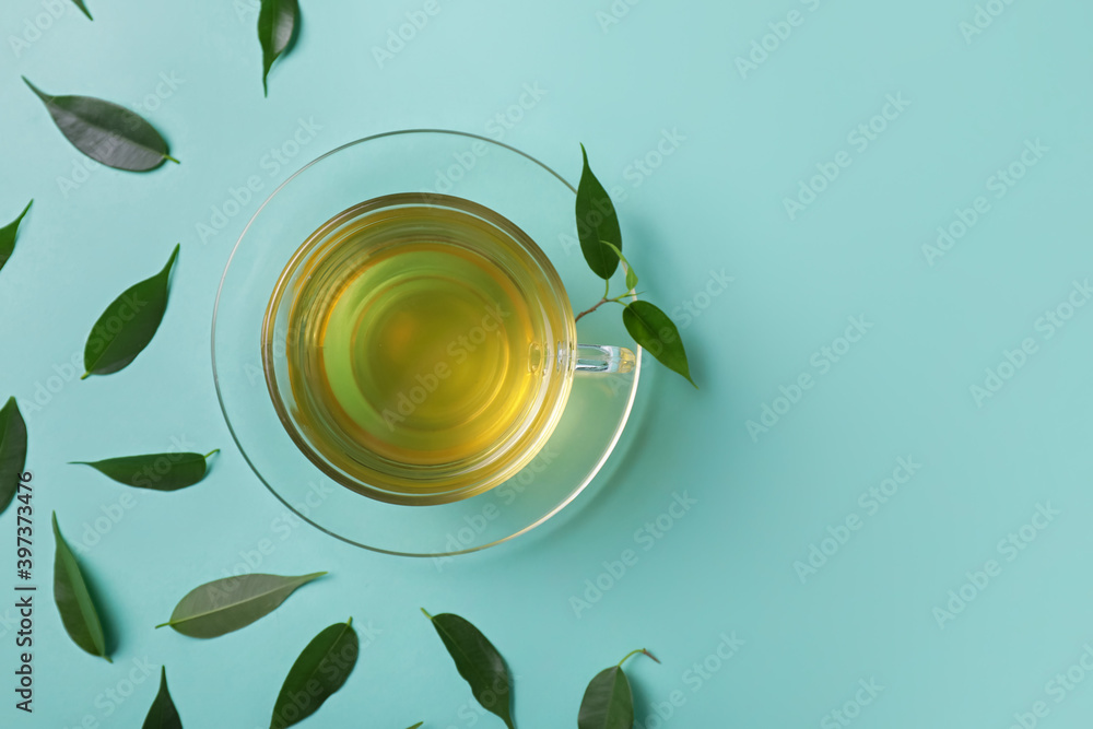 彩色背景的一杯茶和绿叶
