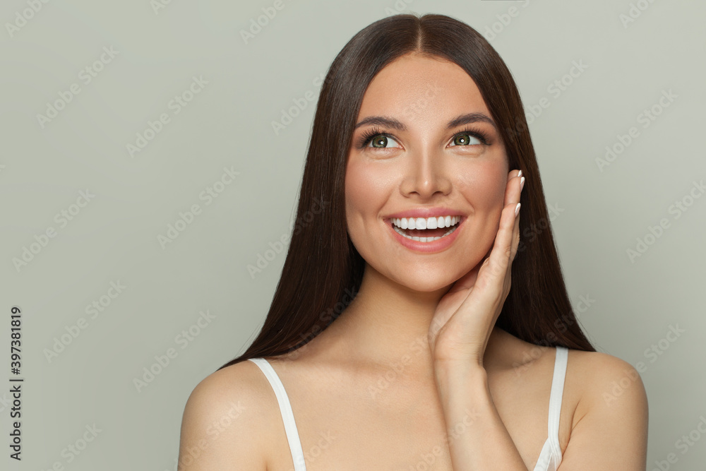 Happy surprised woman spa model with clear skin and long healthy straight hair. Skincare and facial 