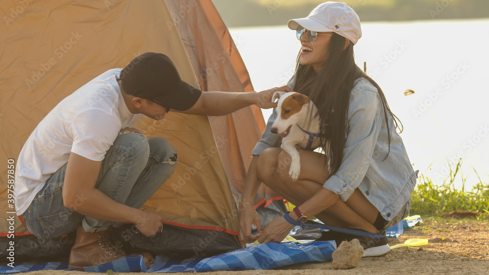 情侣背包客制作帐篷和他们的狗跳起来玩耍的可爱时刻