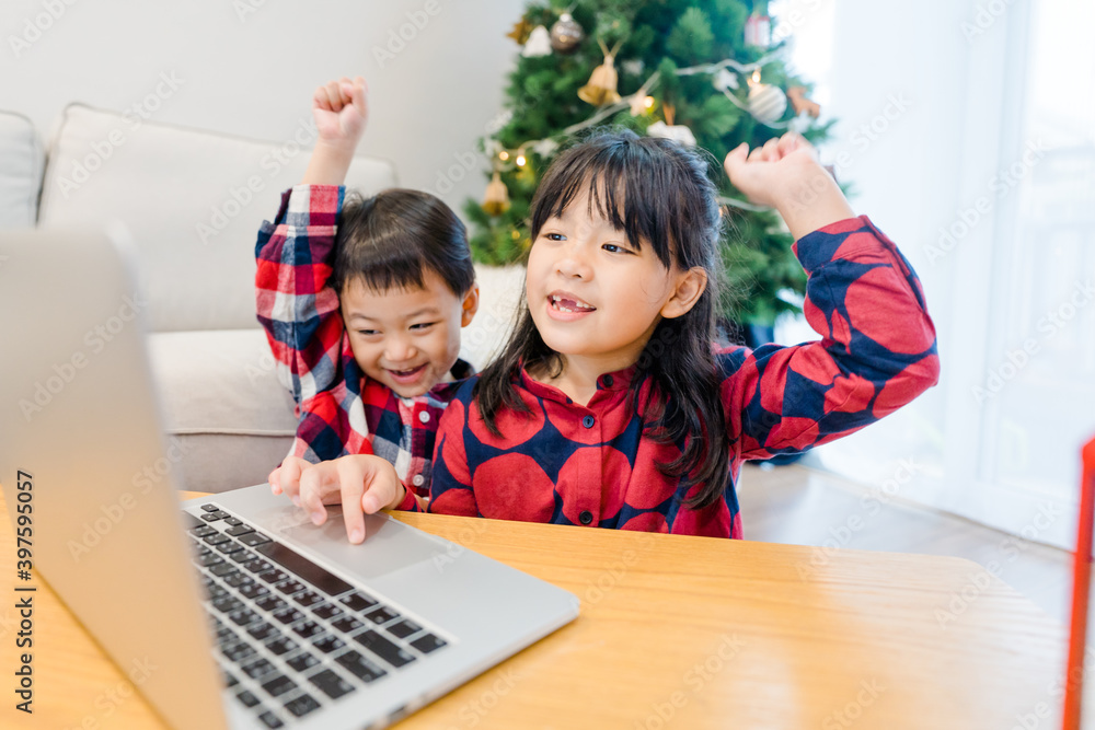 亚洲孩子兄弟姐妹在圣诞节视频通话在家庆祝。在线视频ca