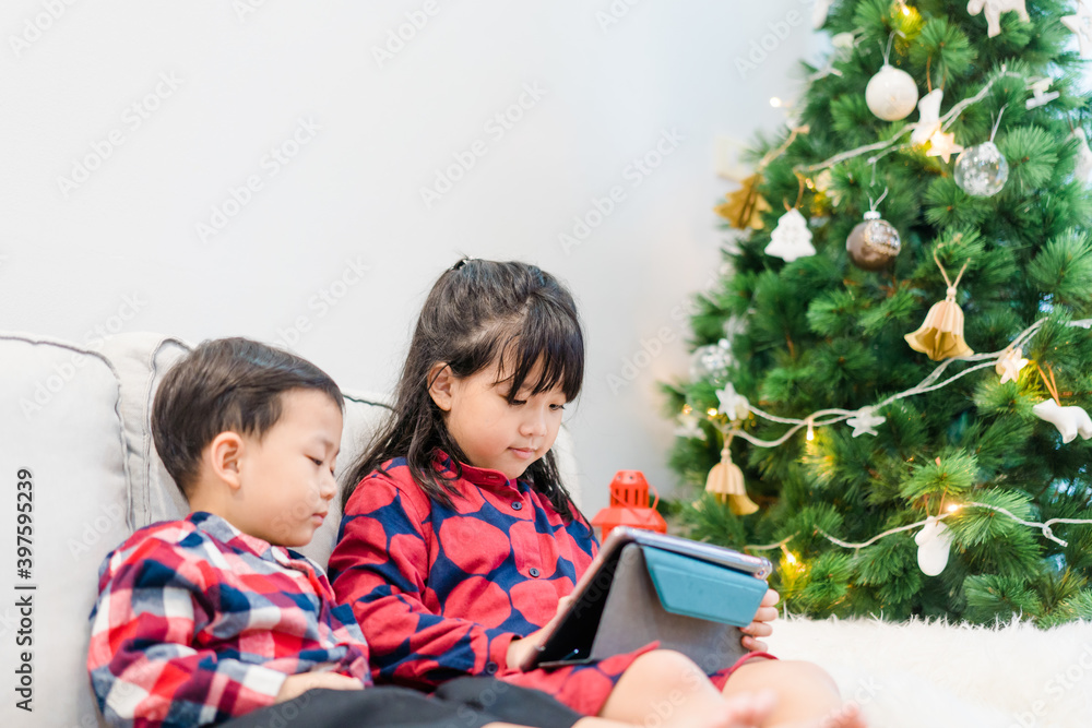 亚洲孩子兄弟姐妹在圣诞节视频通话在家庆祝。在线视频ca