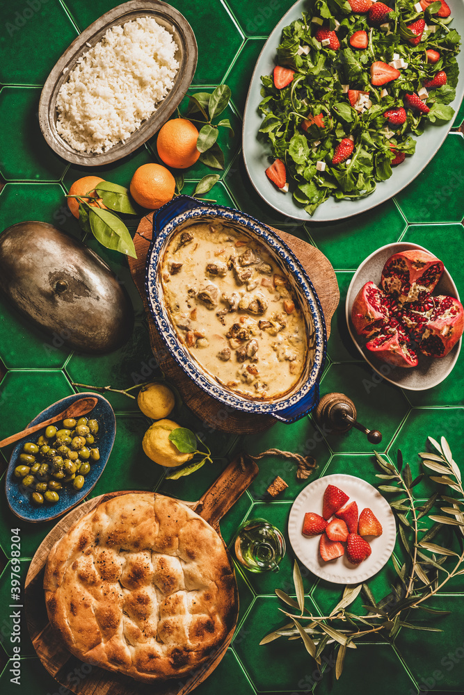 土耳其风格的家庭晚餐。铺着绿色瓷砖的平桌子，上面放着酸奶酱土耳其羊肉和抓饭
