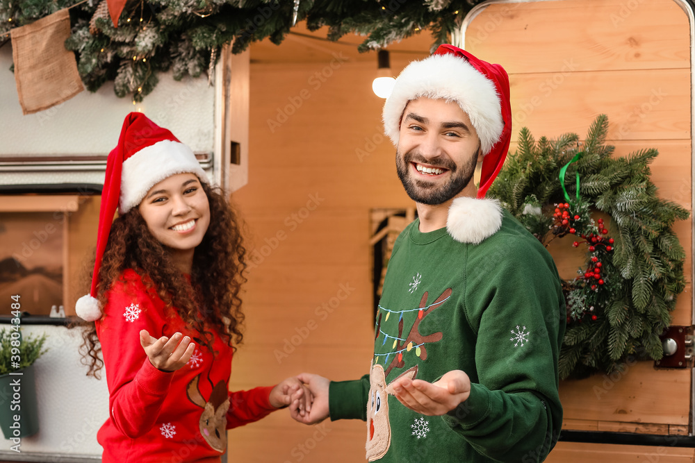 圣诞房车附近幸福的年轻夫妇