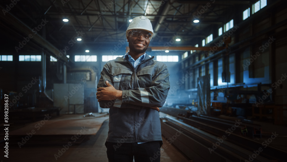 Happy Professional Heavy Industry Engineer/Worker Wearing Uniform, Glasses and Hard Hat in a Steel F
