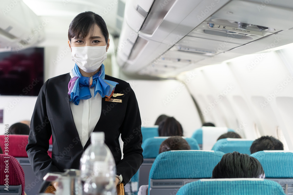 亚洲空姐戴着口罩看着镜头的肖像