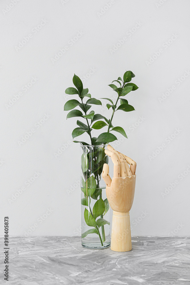 桌上有植物的木制手和花瓶