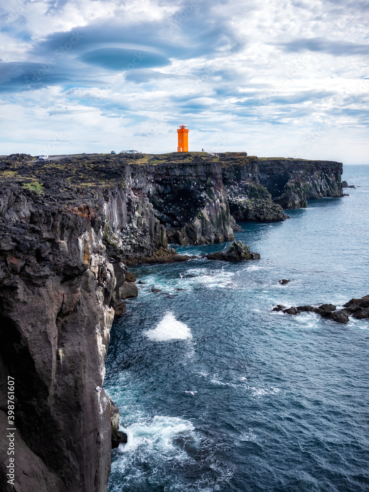 冰岛岩石上的灯塔。白天是高高的岩石和灯塔。夏天是自然景观。