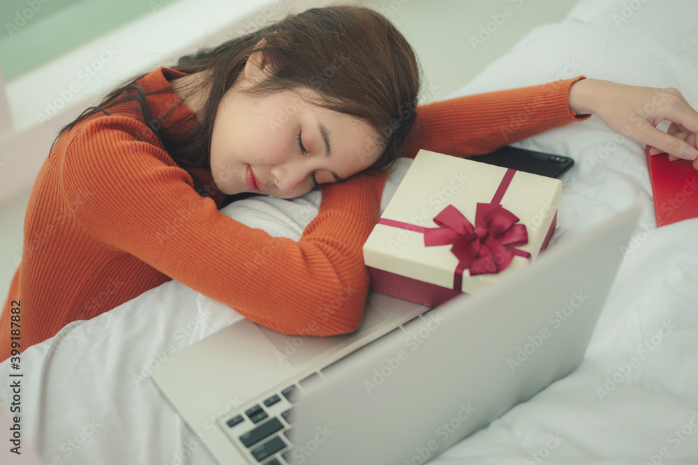 美丽的亚洲女人，黑色头发，在圣诞节睡在笔记本电脑前。