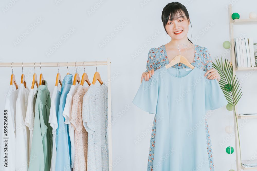 年轻的亚洲美女正在社交平台和电子商务上直播卖衣服