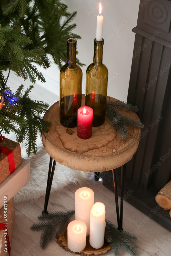 在圣诞树附近燃烧蜡烛和木桌