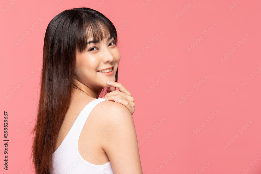 年轻美丽的亚洲女人微笑着，用干净清新的皮肤触摸着下巴。幸福和开朗的机智