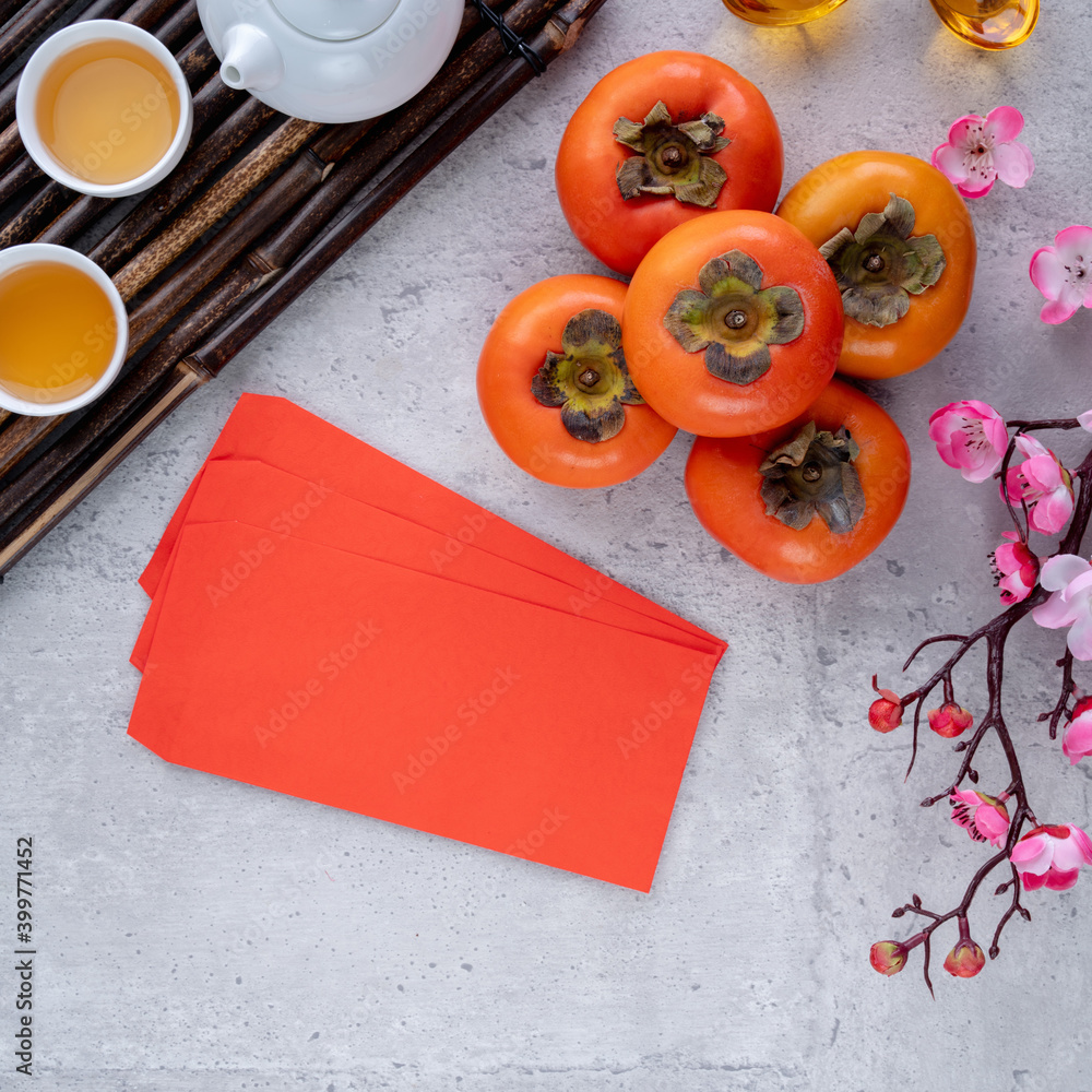 中国农历新年灰色餐桌背景上带叶子的新鲜甜柿子俯视图