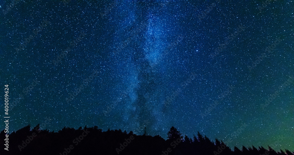 银河系的奇妙星夜，有一位游客和一个帐篷在山脉上