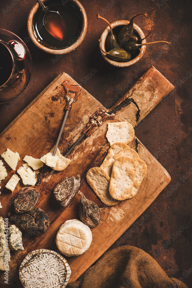 Assortment of snacks and appetizers for red wine concept. Flat-lay of various cheeses, crackers, smo