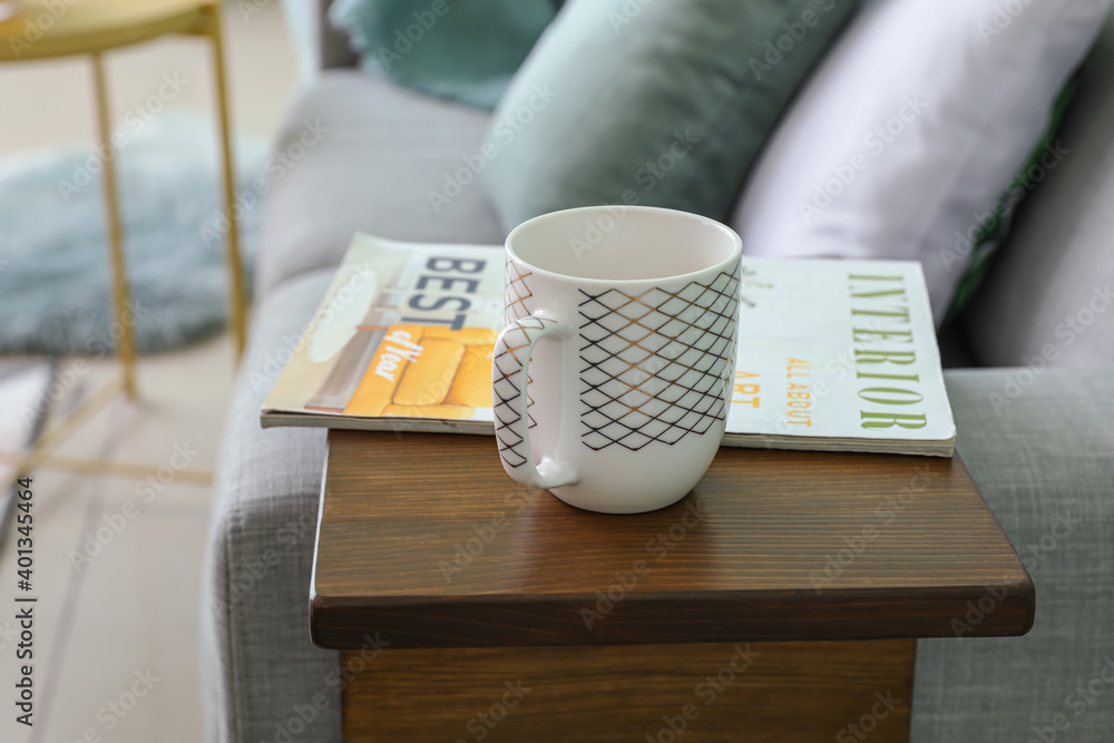房间扶手桌上的一杯茶和杂志