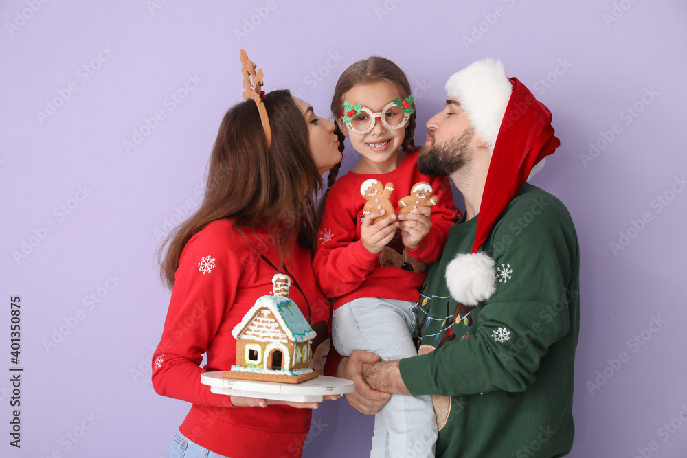 彩色背景姜饼屋的幸福家庭。圣诞节庆祝活动
