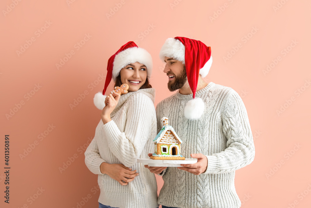 幸福的年轻夫妇，背景是姜饼屋。圣诞节庆祝活动
