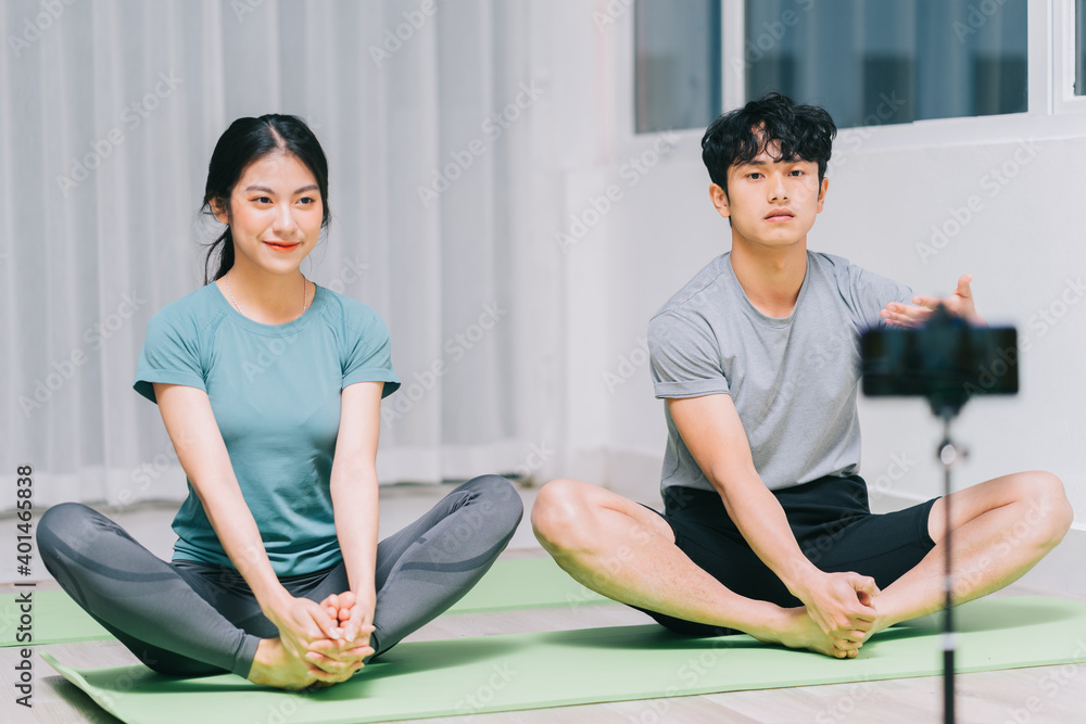 Asian personal trainer is guiding students yoga and video recording to teach yoga online
